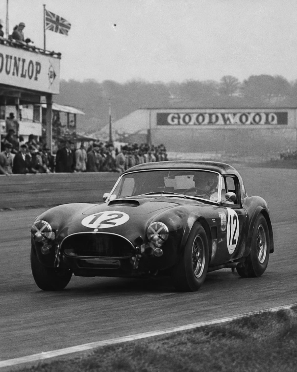 Archive-style photograph of a hard-top V8 roadster racing